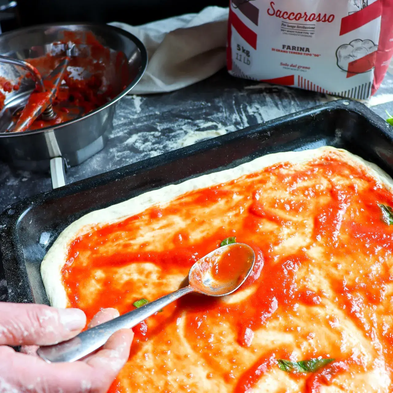 Blechpizza in Stücke geschnitten auf dem Blech