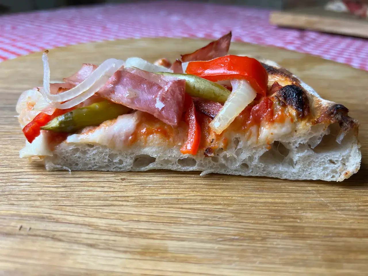 Blechpizza Stück von der Seite mit knusprigem Boden