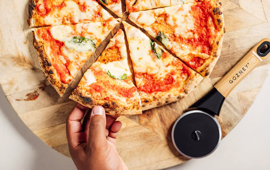Gozney Pizzaschneider liegt neben Pizza