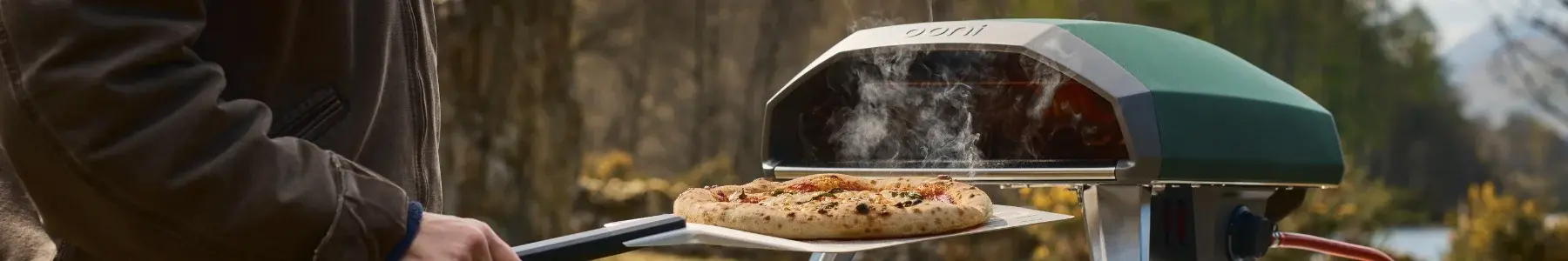 Ooni Koda 2 Grün auf Tisch mit Pizza im Ofen