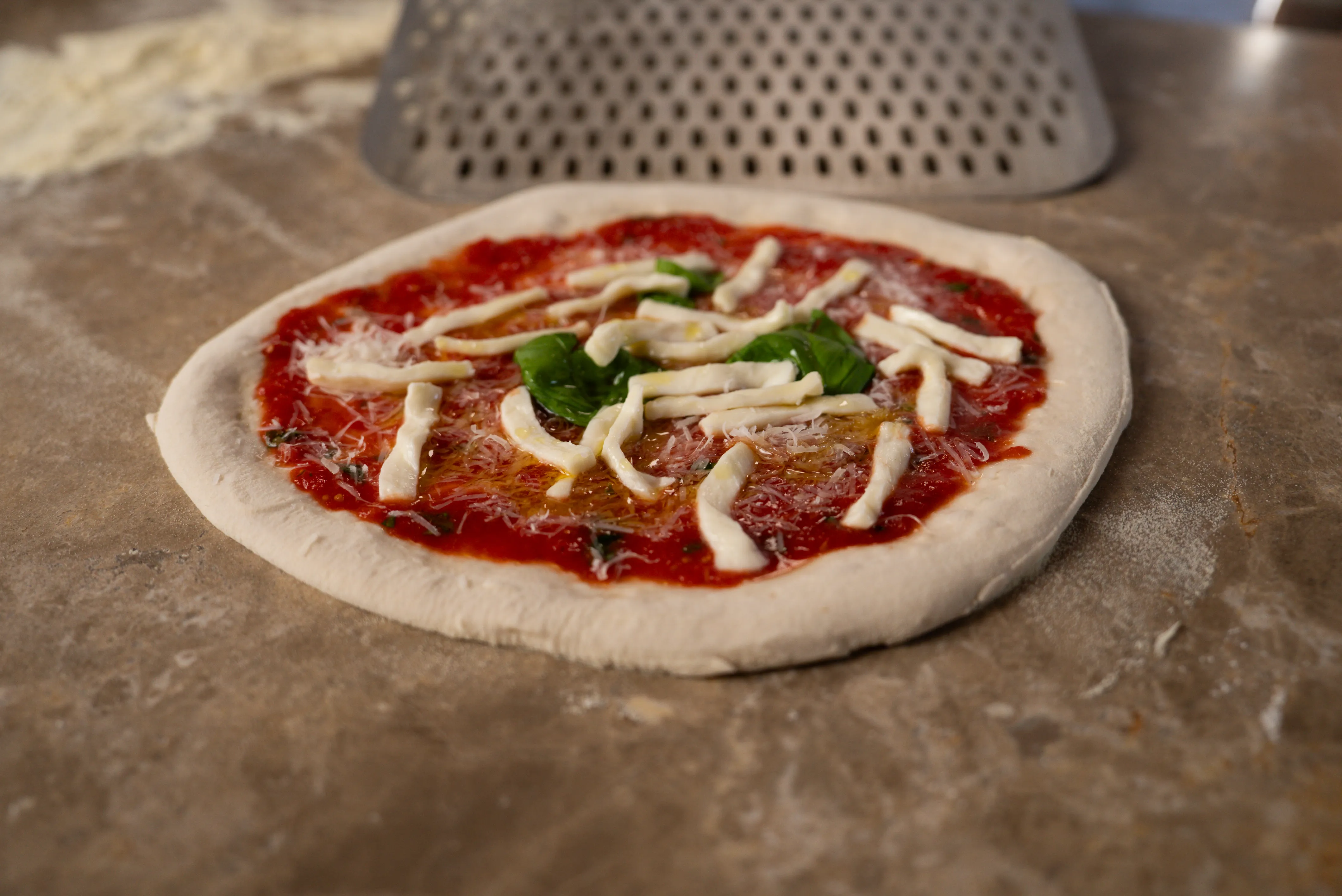 Pizza mit Fior di Latte belegt vor dem Backen
